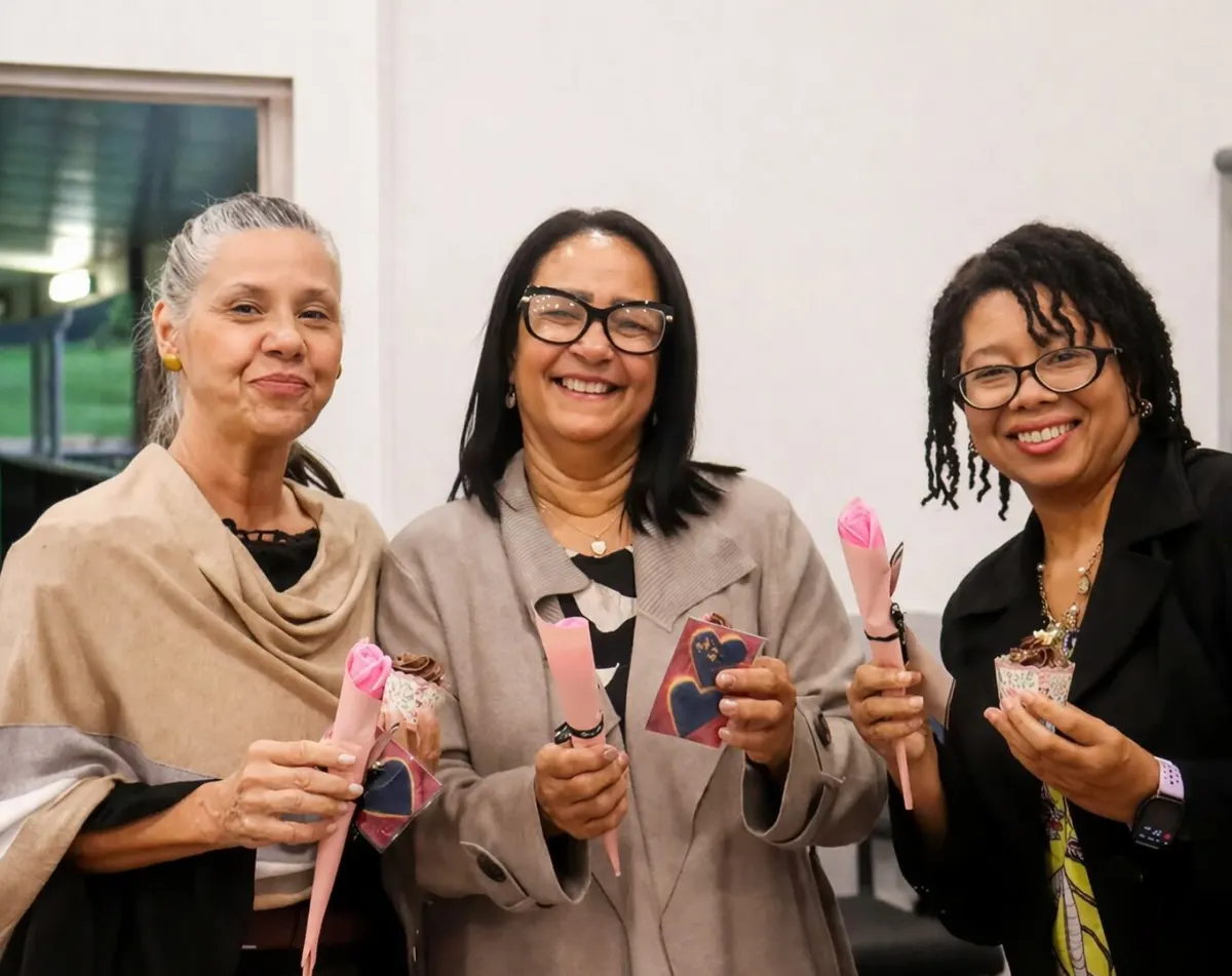 Three women of the church enjoying fellowship with small gifts at a church event