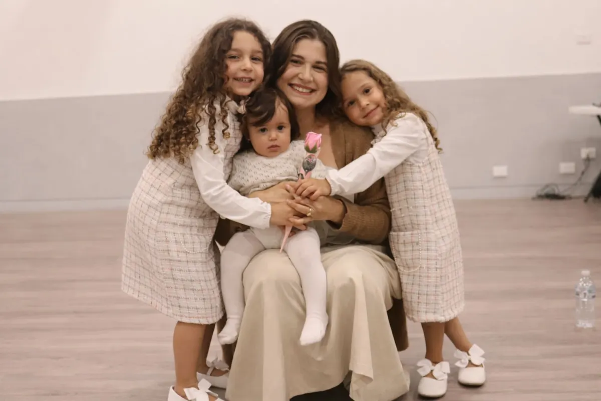 A mother and her three young children smiling together after a church service